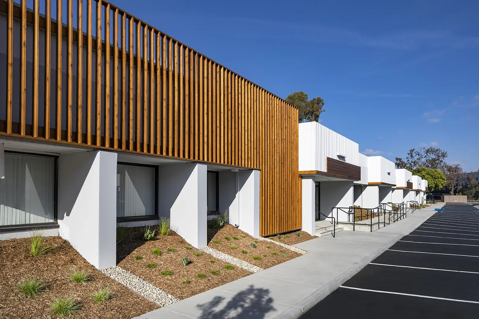 A building with wood and white walls on the side.